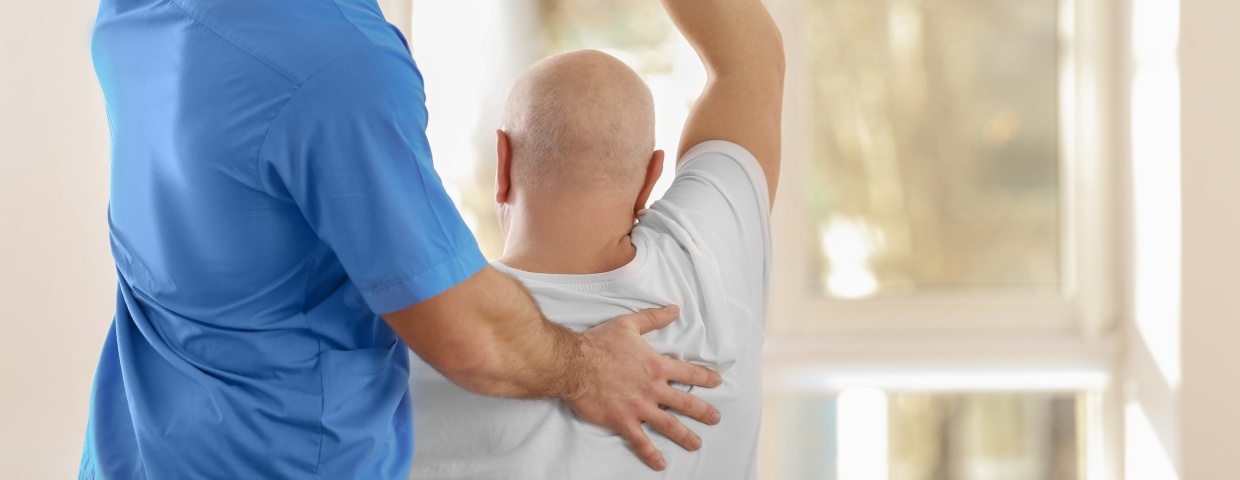 nurse helping man stretch after heart surgery