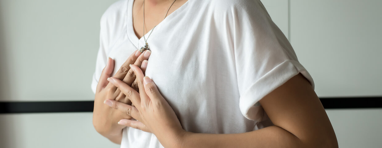 woman holding her sternum or chest after open heart surgery