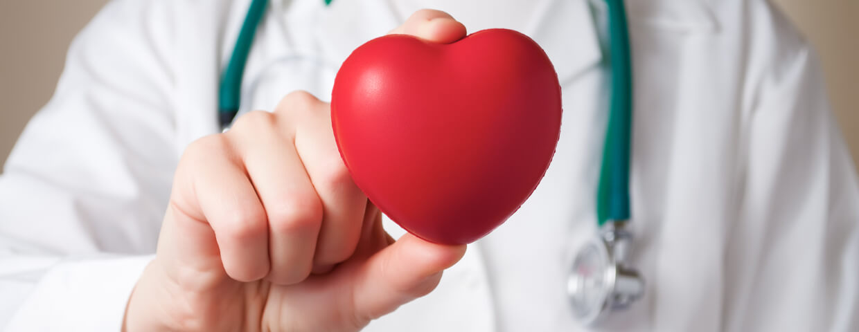 doctor holding out a red heart doctor holding out a red heart